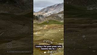 trail crosses a flat green grassy valley before climbing out the other side on Dolomites Alta Via 1 [upl. by Eihtak889]