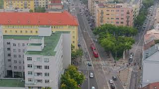 Aerial view of a red tram crossing an intersection in Brno Czech Republic Cars and pedestrians are [upl. by Hewett553]