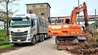 Doosan Dx140wv excavator loading wood onto ChengLong truck [upl. by Yessak963]