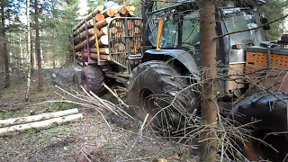 Valtra forestry tractor with big fully loaded trailer logging in wet forest [upl. by Gaidano]