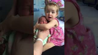 Cute toddler holds baby sister for the first time [upl. by Atnuhs]