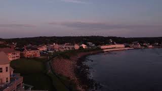 Aerial sunset coastline view of Ogunquit Maine USA drone revealing waterfront homes and resorts [upl. by Yelkcub]